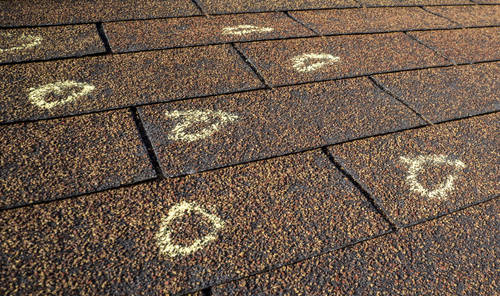 Insurance Adjuster marked hail damage on a insureds roof.
